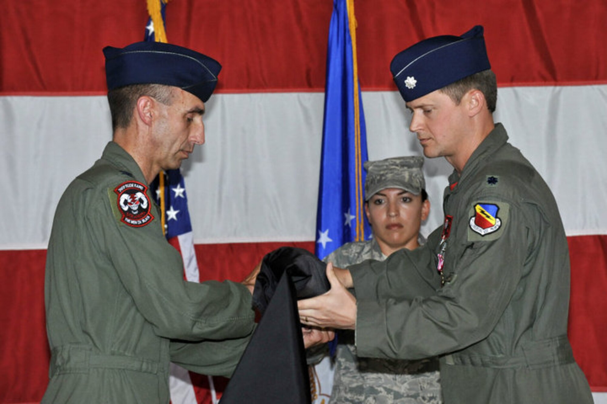 Col. Scott Zobrist, 388th Fighter Wing commander, and Lt. Col. David Lyons, 34th Fighter Squadron commander, case the 34th FS flag during a deactivation ceremony July 16. The 34th FS – one of four fighter squadrons here – was inactivated as part of the force structure plan announced by the Air Force in 2009. Pilots from the 419th Fighter Wing will now fly F-16s from the 4th and 421st Fighter Squadrons, while jets from the 34th FS will be disbursed to other bases. (U.S. Air Force photo/James Arrowood)