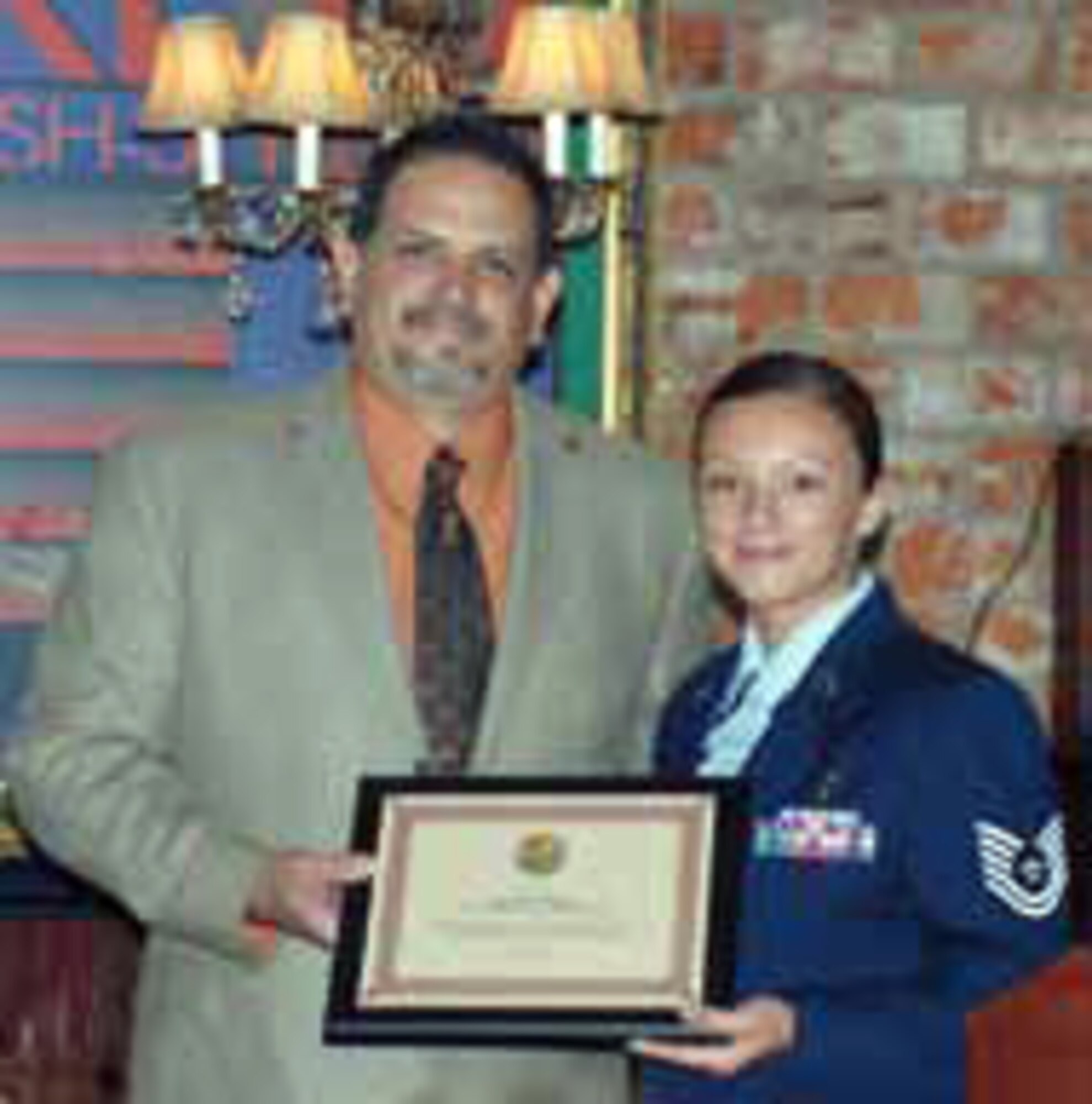 Technical Sgt. Deana Belliveau, 452nd Aeromedical Staging Squadron, accepts a plaque from Mr. Oscar Valdepena, executive director of the Moreno Valley Chamber of Commerce. The Chamber honors an outstanding service member from a unit at March Air Reserve Base each month. (U.S. Air Force photo by Maj. Don Traud)