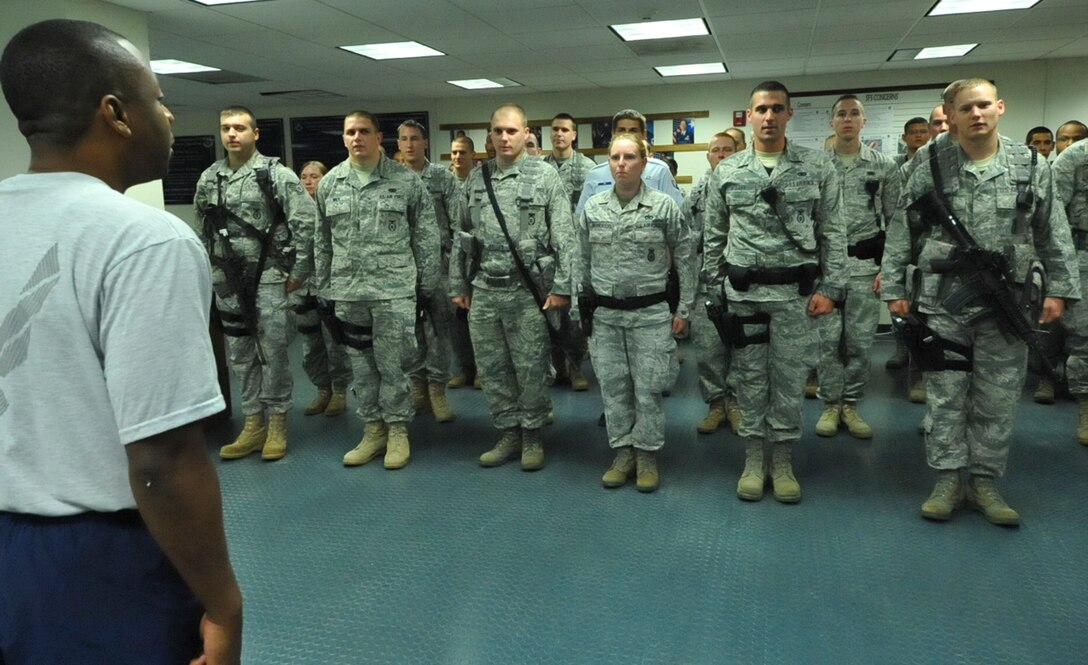 JOINT BASE ANDREWS, Md. -- Chief Master Sgt. Anthony Brinkley, left, 316th Wing/Joint Base Andrews command chief, chants the coveted Airman’s Creed in unison with several 316th Security Forces Squadron members moments after issuing a challenge to 316 SFS members inside the guard mount room of the security forces headquarters July 15.  (U.S. Air Force photo by Bobby Jones)