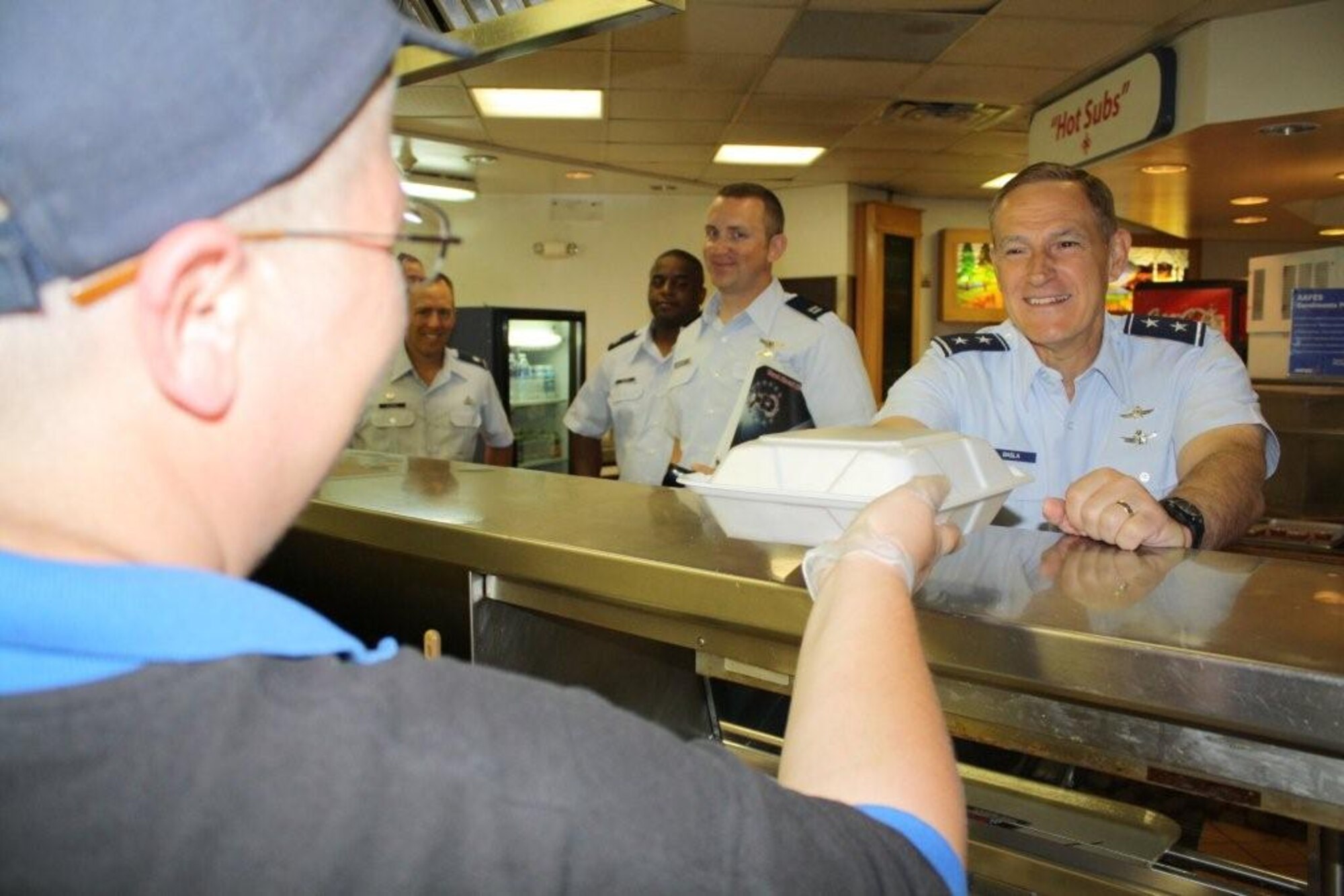 CHEYENNE MOUNTAIN AIR FORCE STATION, Colo. -- Maj. Gen. Michael Basla, Air Force Space Command vice commander, receives his meal from Ms. La-Toya Munson, Army and Air Force Exchange Services Granite Inn dining hall employee July 19. After breakfast General Basla received a detailed orientation on the 721st Mission Support Group's installation support and protection efforts. Additionally, he visited key mission partners including U.S. Strategic Command's Missile Warning Center, North American Aerospace Defense Command/U.S. Northern Command's Alternate Command Center, and the center of the Integrated Tactical Warning/Attack Assessment universe, 721st's own Global Strategic Warning/Space Surveillance System Center. The orientation's focus was to communicate the importance of the diverse elements operating within Cheyenne Mountain that work together to ensure a global warning element in direct support of national security. CMAFS, operated by the 721st MSG, is one of six globally-dispersed installations operated by the 21st Space Wing at Peterson Air Force Base. (U.S. Air Force photo)
