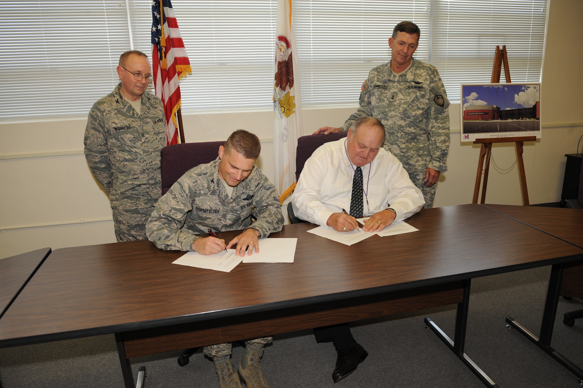 Col. Michael Hornitschek, 375th Air Mobility Wing commander, and Dr. Sam McGowen, Mascoutah Community Unit School District #19 superintendent, sign a Memorandum of Understanding between the Mascoutah district and Scott Air Force Base to ease the transition between schools for military children.  The MOU will help ensure a smooth transition for highly mobile military-affiliated students who move between school districts. With this signing, the base now has MOUs with the school districts that most children connected to the base attend. (U.S. Air Force photo by Senior Aiman Teresa Jennings)