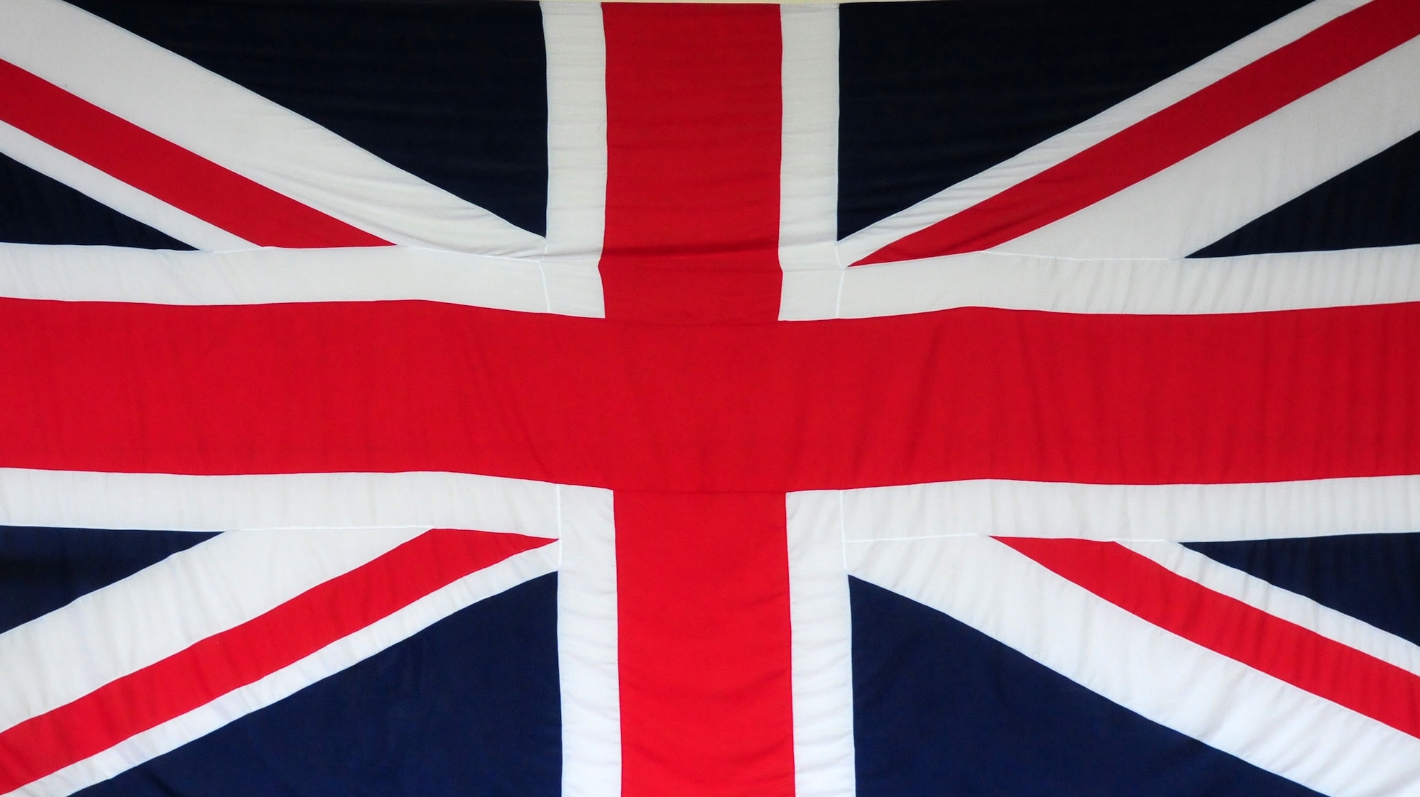 The striking red, white and blue design of the Union Flag today harks back to a time when “Britannia ruled the waves”.While the flag appears symmetrical, the white lines above and below the diagonal red are different widths. On the side closest to the flagpole (or on the left when depicted on paper), the white lines above the diagonals are wider; on the side furthest from the flagpole (or on the right when depicted on paper), the converse is true. Thus, rotating the flag 180 degrees will have no change but, if mirrored, the flag will be upside-down.
Placing the flag upside down is considered an offence against the dignity of the reigning sovereign.(U.S. Air Force photo by A1C Lausanne Morgan)