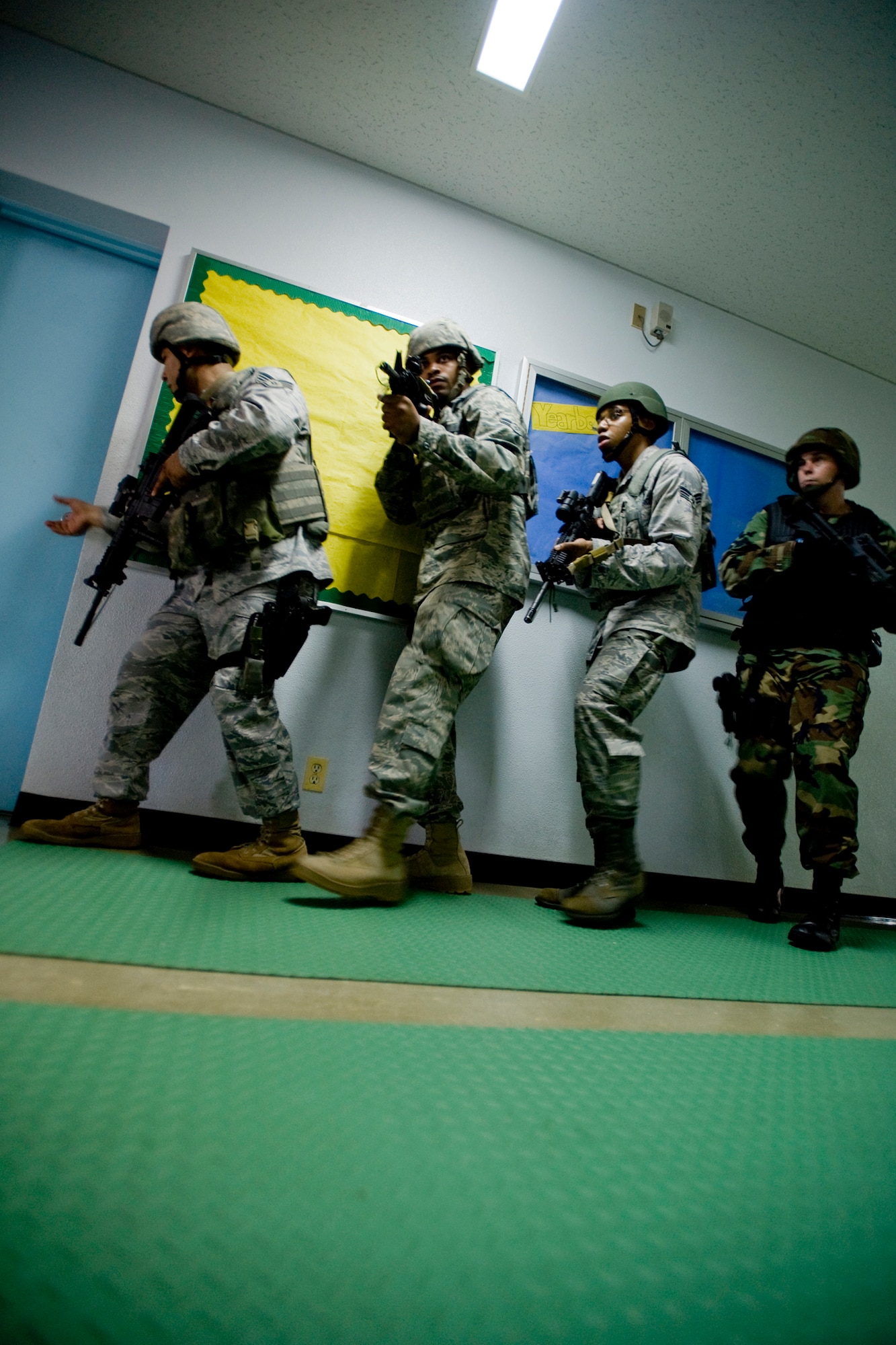 MISAWA AIR BASE, Japan -- Staff Sgt. Anthony Santillan, Airman 1st Class Steven Howard Jr. and Senior Airman Rolland Gould, all with the 35th Security Forces Squadron, along with Petty Officer 1st Class Jason Clark, Naval Air Facility security operations supervisor, train on quick-reaction response tactics July 22 at Robert D. Edgren High School. The training was part of a high-risk response program taught to base security members that will allow them to respond to an active shooter incident. (U.S. Air Force photo/Senior Airman Jamal D. Sutter)