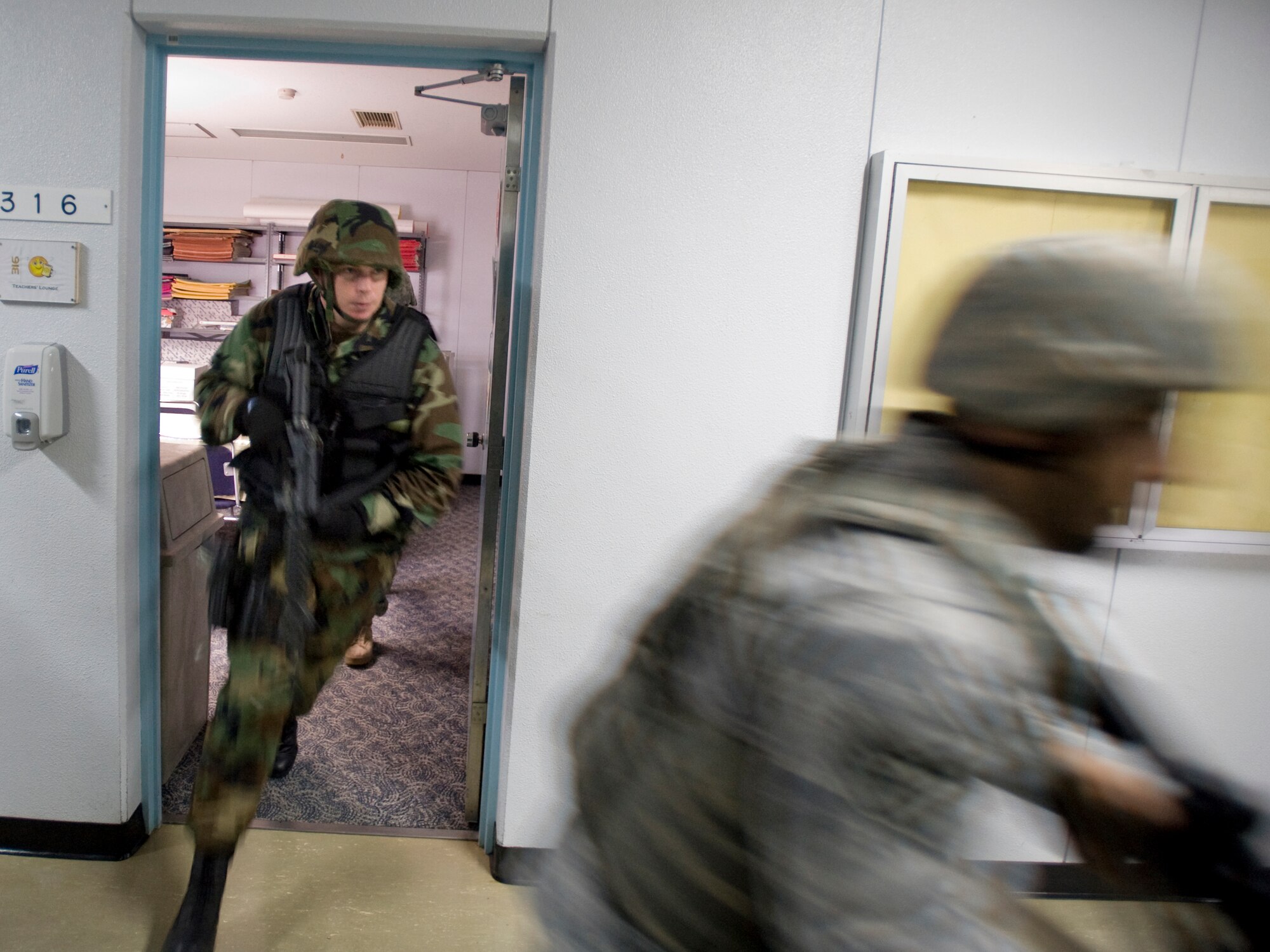 MISAWA AIR BASE, Japan -- Petty Officer 1st Class Jason Clark, Naval Air Facility security operations supervisor, quickly exits a Robert D. Edgren High School classroom July 22 during high-risk response training. Eleven 35th Security Forces Squadron defenders and three NAF master at arms participated in the program. (U.S. Air Force photo/Senior Airman Jamal D. Sutter)