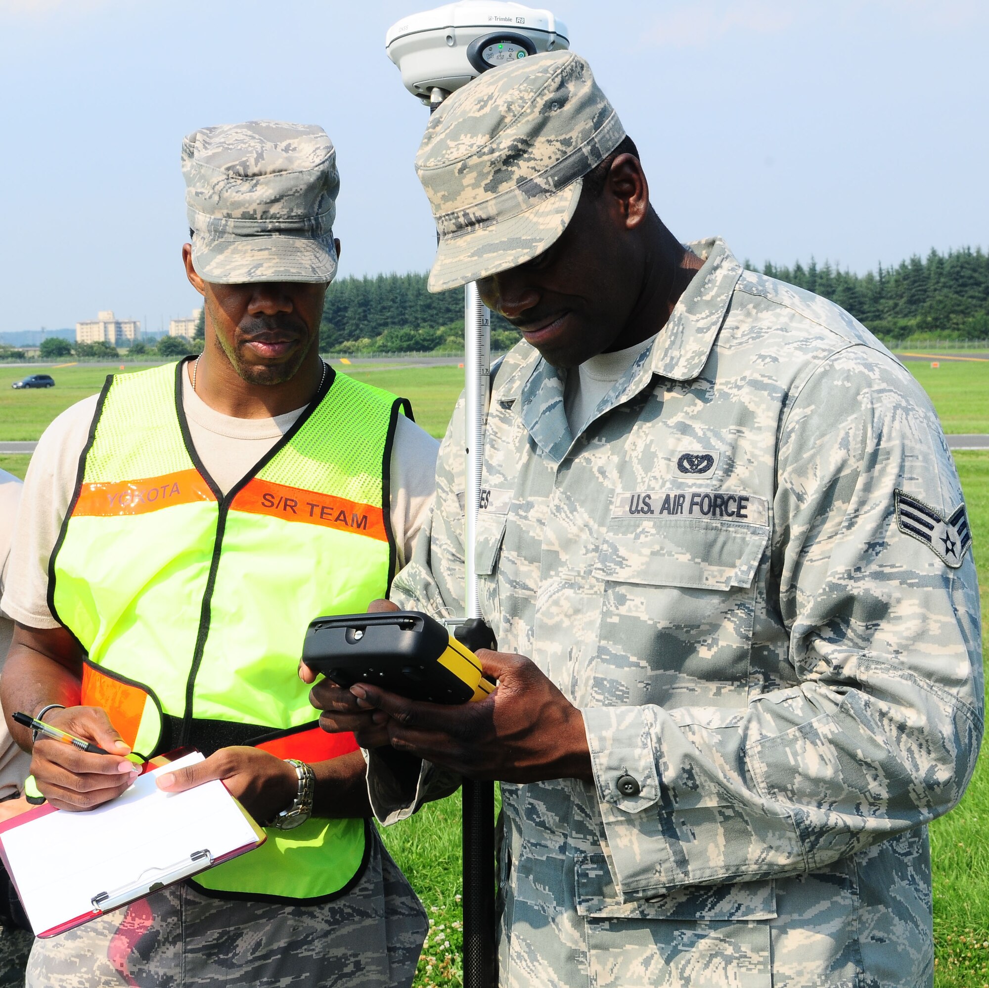 YOKOTA AIR BASE, Japan -- Staff Sgt. Frederick Guild, (left) 374th Force Support Squadron guest services representative, and Senior Airman Jason Holmes, 374th Civil Engineer Squadron geo base technician, record the coordinates of an object July 22 during the Search and Recovery Core Team Training. The coordinates are placed onto a grid that shows where each item was found. (U.S. Air Force photo/Airman 1st Class Sean Martin)