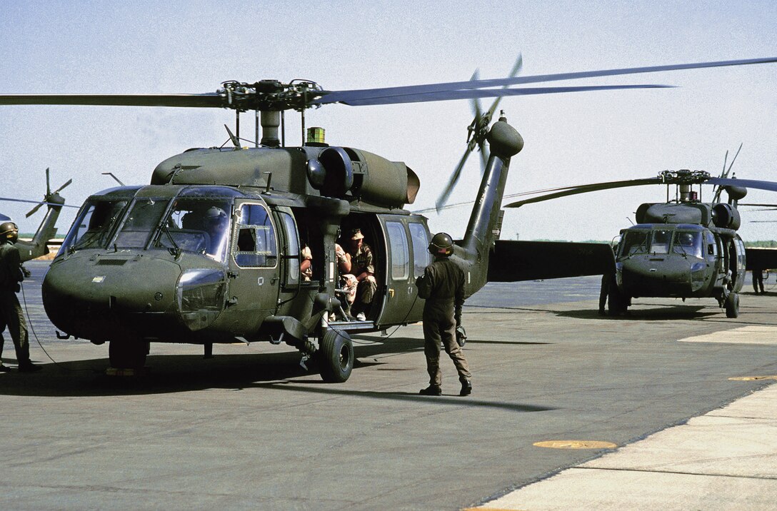 U.S. Army Gen. Colin Powell, chairman of the Joint Chiefs of Staff, sits in a UH-60 Blackhawk helicopter with 82nd Airborne personnel as he prepares for takeoff. Powell visited the base camp during Operation Desert Shield.