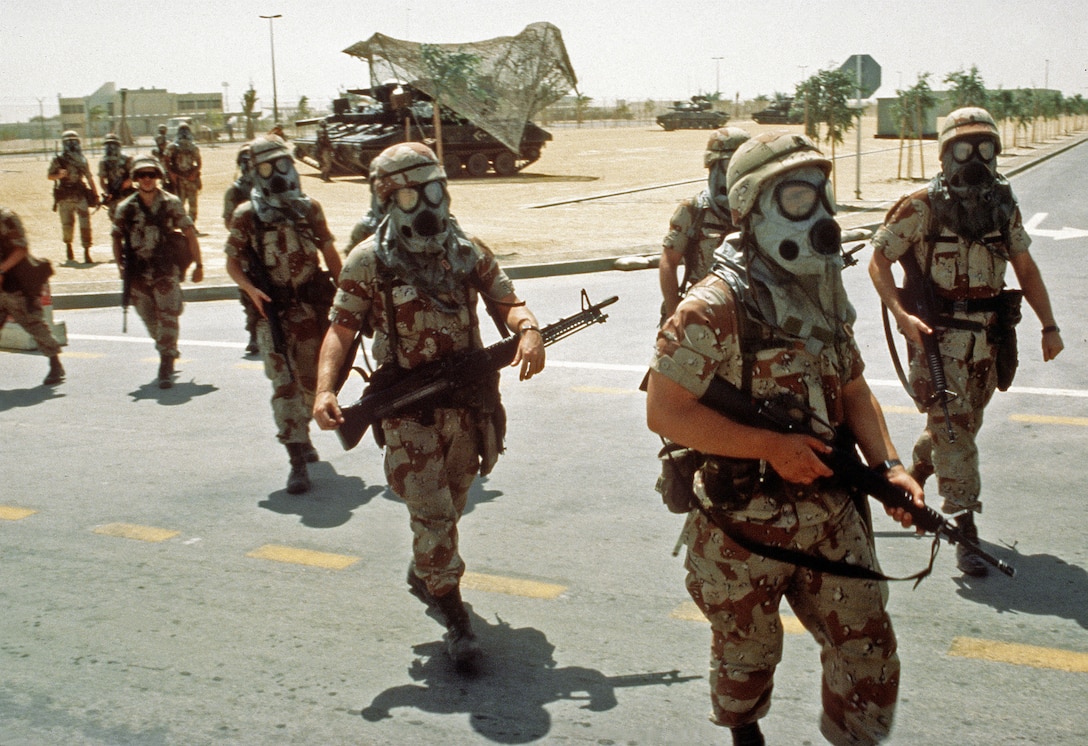 Soldiers from the 82nd Airborne Division wear their M-17A1 protective masks while conducting training during Operation Desert Shield. Several M-551 Sheridan light tanks are in the background.