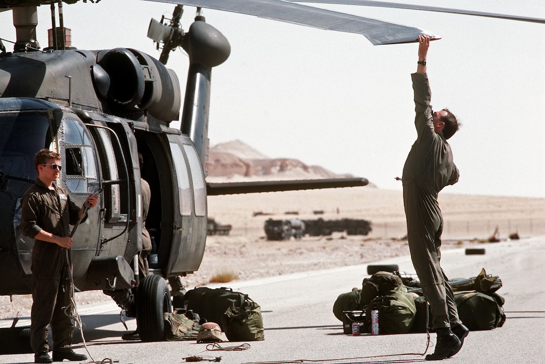 U.S. Air Force Capt. James Dygert checks a propeller of a UH-60A Blackhawk helicopter during Operation Desert Shield. Dygert is on interservice assignment as executive officer for Company B, 2nd Battalion, 82nd Aviation Brigade. and is responsible for transporting troops to the front.
