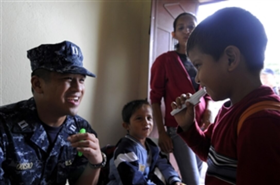 U.S. Navy Lt. Michael Quisao (left) plays the kazoo with a student from Escuela de Las Pampas during a community relations event with U.S. sailors, Marines and airmen embarked on the high speed vessel Swift (HSV-2) in Escuntila, Guatemala, during Southern Partnership Station 2010, a deployment of specialty platforms to the U.S. Southern Command area of responsibility in the Caribbean and Latin America on July 19, 2010.  