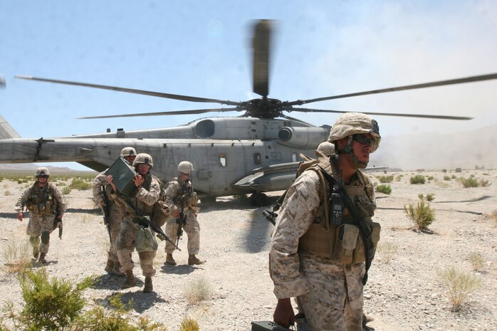 Marines with Golf Company, 2nd Battalion, 1st Marine Regiment, exit a CH-53E Super Stallion helicopter to deliver ammunition during a clear, hold, build 2 exercise on Range 210 at the Marine Corps Air Ground Combat Center Twentynine Palms, Calif., July 23.