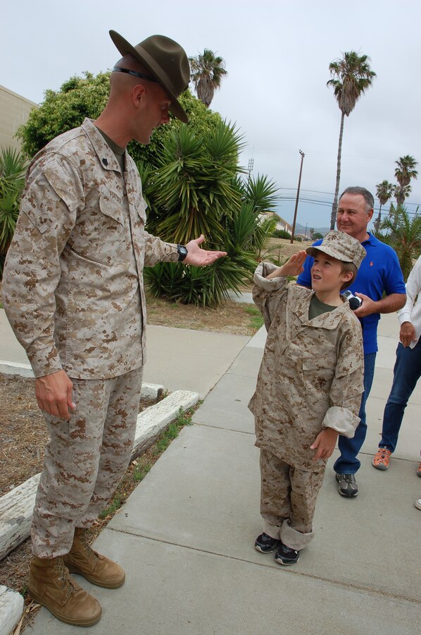 Staff Sgt. Jeremy Hager, routing chief for WFTBN and a St. Louis, Mo., native, explains how to conduct a proper salute to 11-year-old Riley Lamberson as his grandfather, Jack Riley looks on. Riley, who has cystic fibrosis, spent a day with Marines at Marine Corps Base Camp Pendleton, Calif., July 23, as part of his wish with the Make-a-Wish Foundation. (Official Marine Corps photos by Staff Sgt. Marc Ayalin)