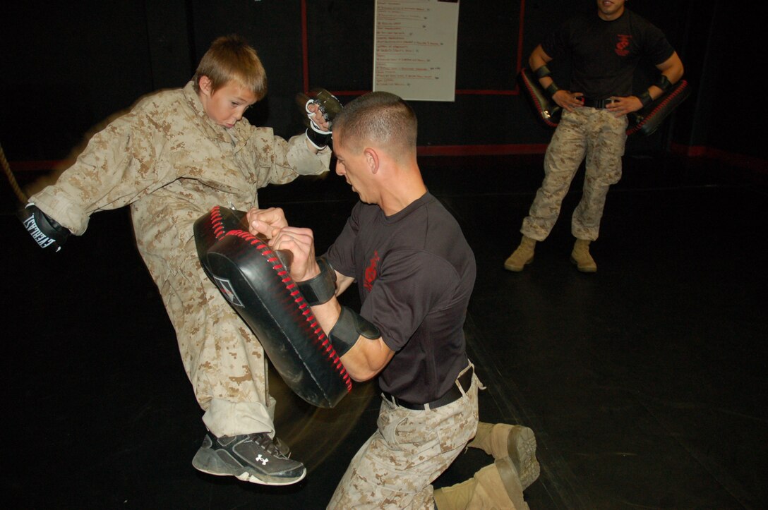 Eleven-year-old Riley Lamberson executes a round kick with Sgt. Christopher Taylor, chief Marine Corps Martial Arts instructor, Weapons and Field Training Battalion and a Scottsburg, Ind., native. Riley, who has cystic fibrosis, spent a day with Marines at Marine Corps Base Camp Pendleton, Calif. July 23, as part of his wish with the Make-a-Wish Foundation. (Official Marine Corps photos by Staff Sgt. Marc Ayalin)