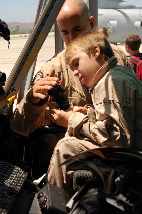 Maj. Chris Chown, pilot, Marine Light Attack Helicopter Squadron 267, 3rd Marine Aircraft Wing, shows eleven-year-old Riley Lamberson the controls of a UH-1Y Huey helicopter during his visit to Marine Corps Air Station Camp Pendleton, Calif., July 23. It was Riley’s wish with the Make-a-Wish Foundation to spend a day with the Marines. (Official Marine Corps photos by Staff Sgt. Marc Ayalin)