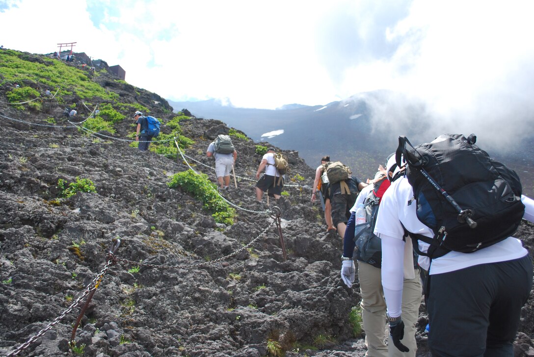 Aircraft Rescue Fire Fighting Marines climb up to the next station during ARFF’s annual Mt. Fuji climb July 24. Mt. Fuji is home to many torii towers and shrines resting at various locations around the dormant volcano. Mt. Fuji is the highest and holiest mountain in Japan, which extends 12,355 meters into the sky.
