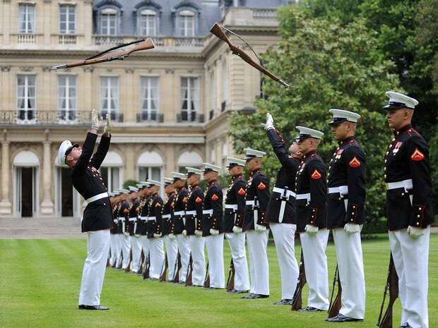 Lance Cpl. Nicholas Meekins and Lance Cpl. Michael Hintz simultaneously spin rifles during a performance at the U.S. Ambassador's House in Paris, France.