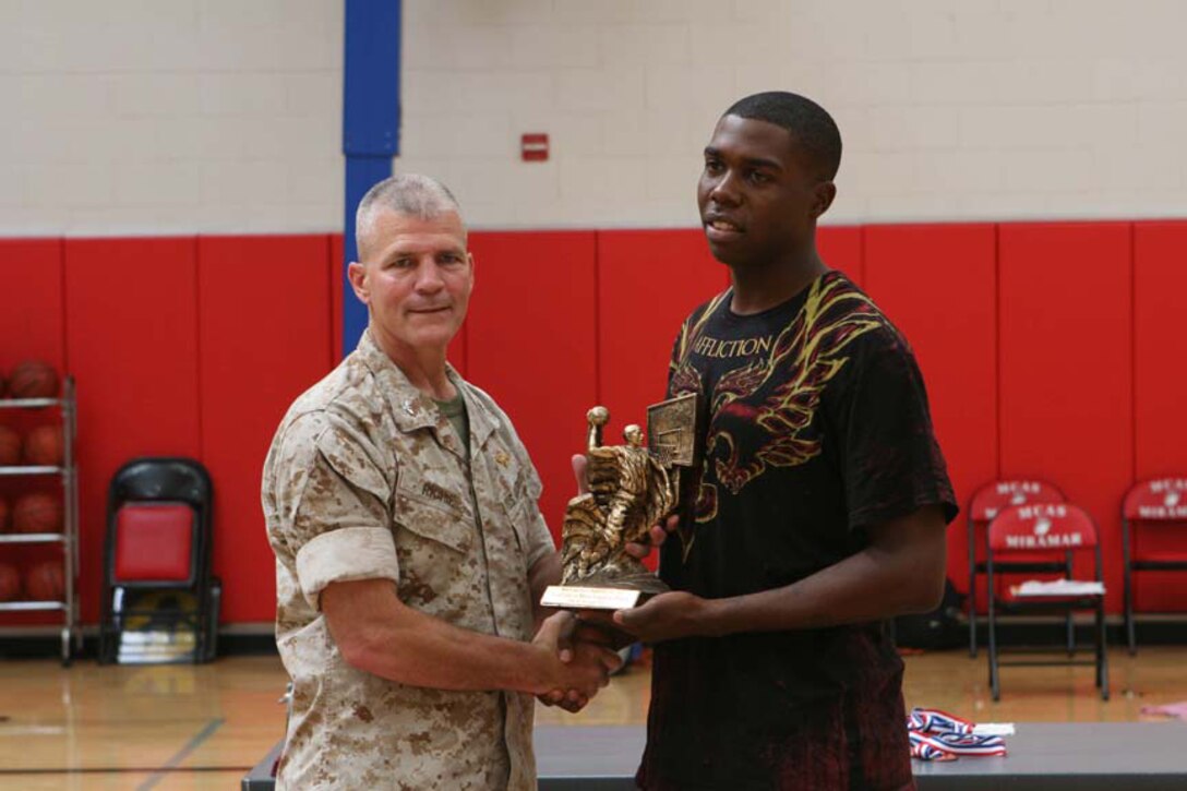 Col. Frank A. Richie, the commanding officer of Marine Corps Air Station Miramar in San Diego, awards the most valuable basketball player title to Christopher Harris, small forward, July 23, 2010, after the Marine Corps West Coast Regional Tournament. Harris, with the Marine Corps Air Station in Yuma, Ariz., was named to the all-tournament team along with other Yuma players. The team finished third overall, losing to Miramar in the first elimination round July 22, 2010.