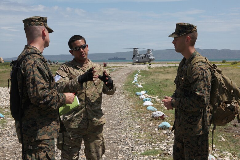 Marines with Company A, 2nd Assault Amphibian Battalion, Special-Purpose Marine Air-Ground Task Force Continuing Promise 2010, speak with Chilean Marine Corps Lt. Diego Rojas about the security aspect in Haiti.  The Special-Purpose Marine Air-Ground Task Force will be augmenting host nation security to ensure that humanitarian aid such as medical, dental, veterinarian, and engineering support is delivered safely and effectively.