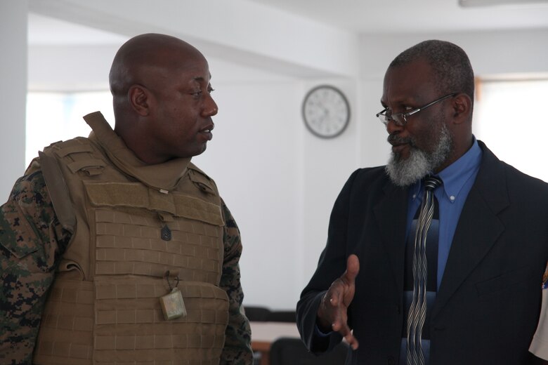 Gunnery Sgt. Felder Domond, a native of Port-au-Prince, Haiti, speaks with Guillet Salvador, mayor of Port-de-Paix, Haiti, about the missions that will be conducted in Haiti, July 24, 2010. Salvador and Haiti National Police led Marines and Sailors to various mission sites in Port-de-Paix in preparation for military personnel and non-government officials to conduct humanitarian civic assistance as part of Operation Continuing Promise 2010.
