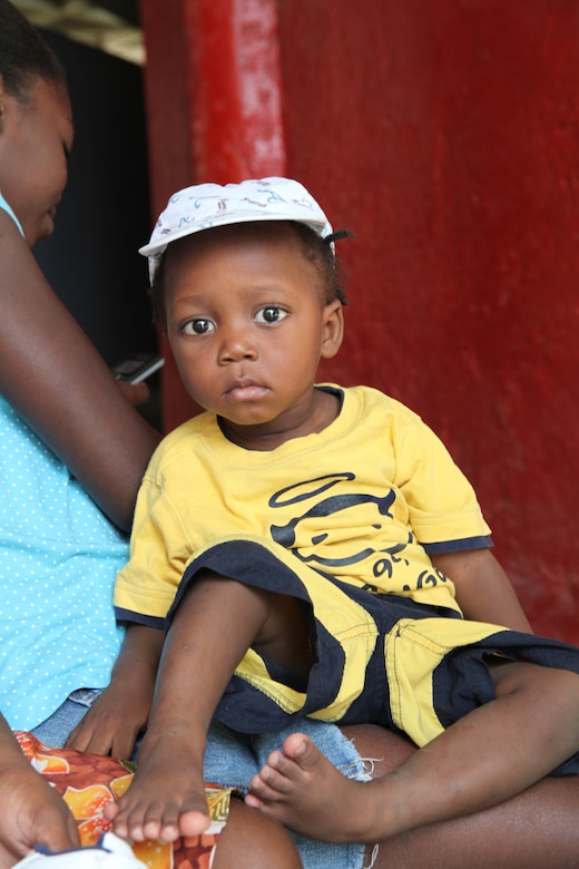 A Haitian child sits with his Mother after a medical screening at Guillaud Haitian School, July 24, in Port-de-Paix, Haiti. The child has six toes on each foot and his mother hopes for the sixth toe to be surgically removed. Marines and Sailors of the USS Iwo Jima visited the school as part of a mission site screening throughout Port-de-Paix in preparation for military personnel and non-government officials to conduct humanitarian efforts during Operation Continuing Promise 2010.