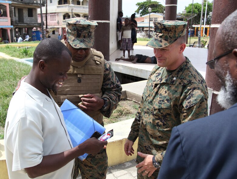 The mayor of Saint Louis du Norde in Port-de-Paix, Haiti, holds a Marine Corps sticker given by Lt. Col. Chris S. Richie, commanding officer of Special-Purpose Marine Air-Ground Task Force Continuing Promise 2010, July 24, 2010. Haiti National Police led Marines and Sailors of the USS Iwo Jima throughout Port-de-Paix as they visited each mission site where military personnel and non-government officials will conduct humanitarian civic assistance as part of Operation Continuing Promise 2010.
