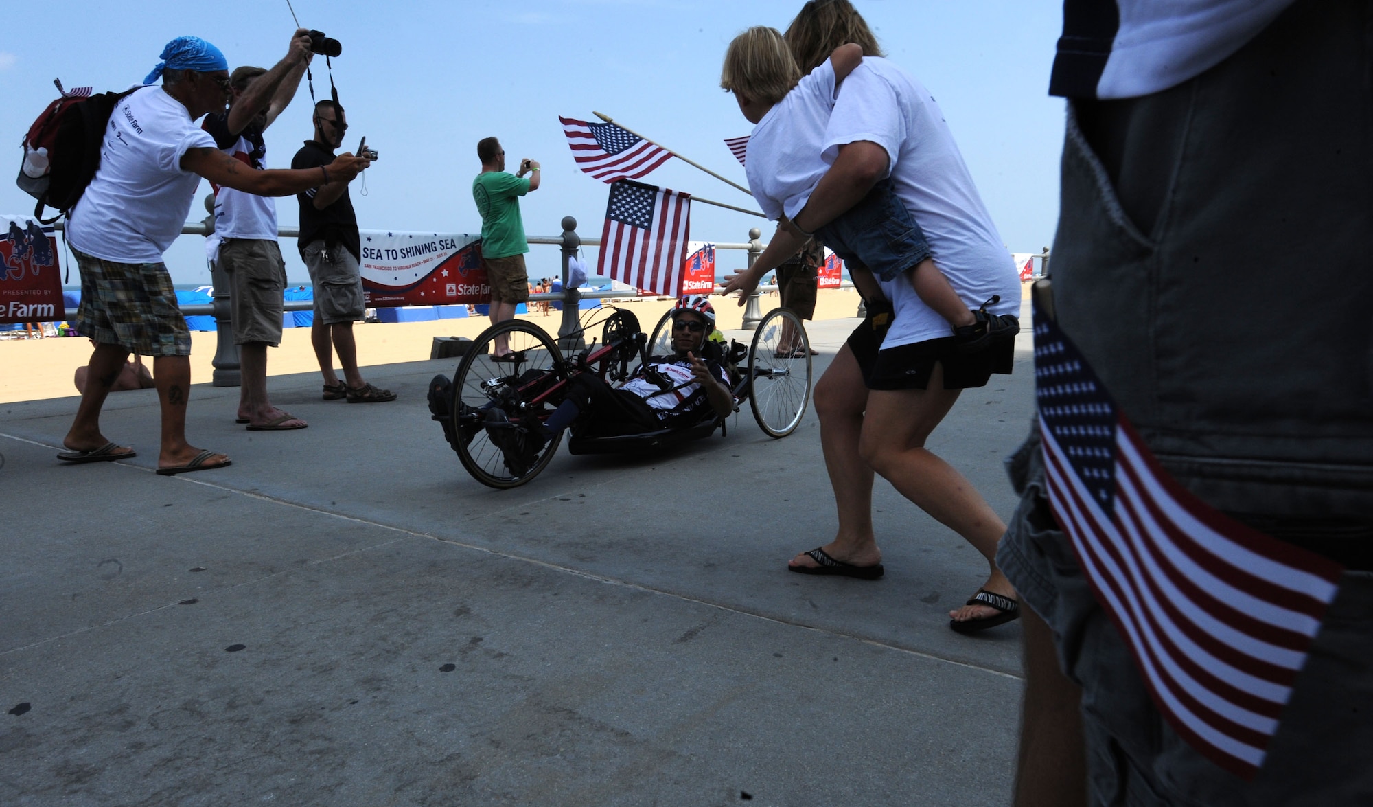 LANGLEY AIR FORCE BASE, Va. -- Eric Frazier, Sea to Shining Sea rider, arrives in Virginia Beach July 24 to a crowd of family members and local supporters. Sea to Shining Sea is a 4000 mile bike ride which started at the Golden Gate Bridge and ended in Virginia Beach and includes injured military and a few able-bodied cyclists honoring the courage of our military and the strength of the American spirit. (U.S. Air Force Photo/Staff Sgt. Christina M. Styer