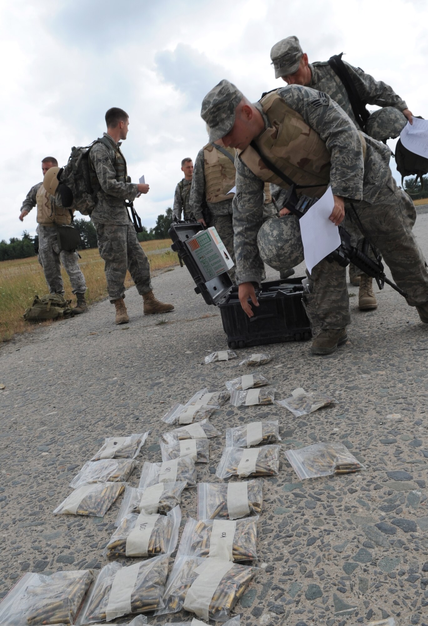 U.S. Air Force Airmen pick-up rifle ammunition prior to weapons qualifying during Exercise Allied Strike 10, Grafenwoehr, Germany, July 23, 2010. Allied Strike is Europe's premier close air support (CAS) exercise, held annually to conduct robust, realistic CAS training that helps build partnership capacity among allied North Atlantic Treaty Organization nations and joint services while refining the latest operational CAS tactics. For more ALLIED STRIKE information go to www.usafe.af.mil/alliedstrike.asp. (U.S. Air Force photo by Senior Airman Caleb Pierce)