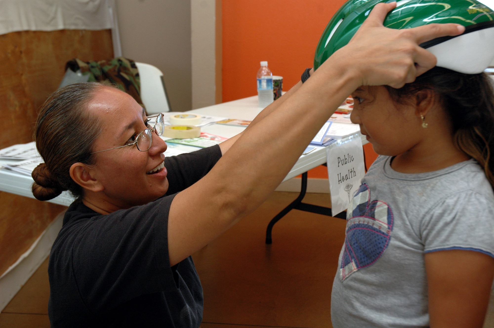 Capt. Elzadia Kainae, 154th Medical Group, clinical nurse, measures a bike helmet on a young child during the Innovative Readiness Training, July 16, in Waianae, Hawaii.  Innovative Readiness Training is an opportunity for Guard members to complete training while performing free medical services to the community. (U.S. Air Force photo/Tech. Sgt. Betty J. Squatrito-Martin)