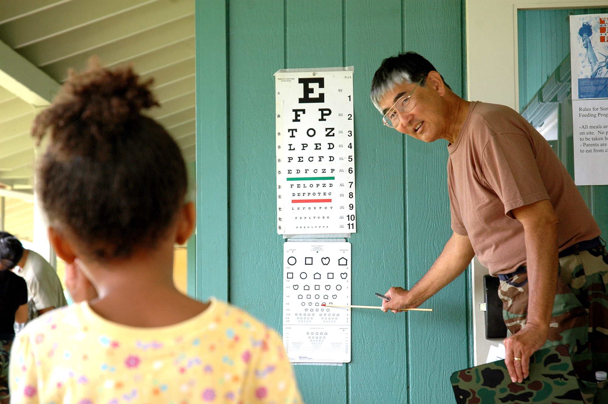 Master Sgt. Alan Yoneshige, 154th Medical Group, optometry technician, administers an eye exam to a young girl during Hawaii Medical Innovative Readiness Training July 16, in Waianae, Hawaii. Innovative Readiness Training is designed to give Guard members an opportunity to complete mission essential training while addressing community and civic needs. (U.S. Air Force photo/Tech. Sgt. Betty J. Squatrito-Martin)