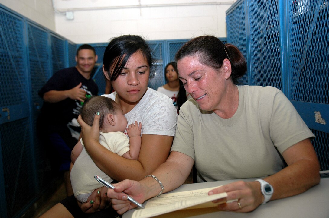 Lt. Col. Susan Richards, 154th Medical Group, chief nurse, confers with Waianae High School student, Kahea-Makani Hussey, about the sports physical assessment. The 154th Medical Group along with Guardsmen from Kentucky and Iowa performed over 150 sports physicals to student athletes at Waianae High School in Waianae, Hawaii, July 14. The sports physicals were given as part of the Innovative Readiness Training that took place July 12-17 on the Leeward Coast of Oahu. (U.S. Air Force photo/Tech. Sgt. Betty J. Squatrito-Martin) 