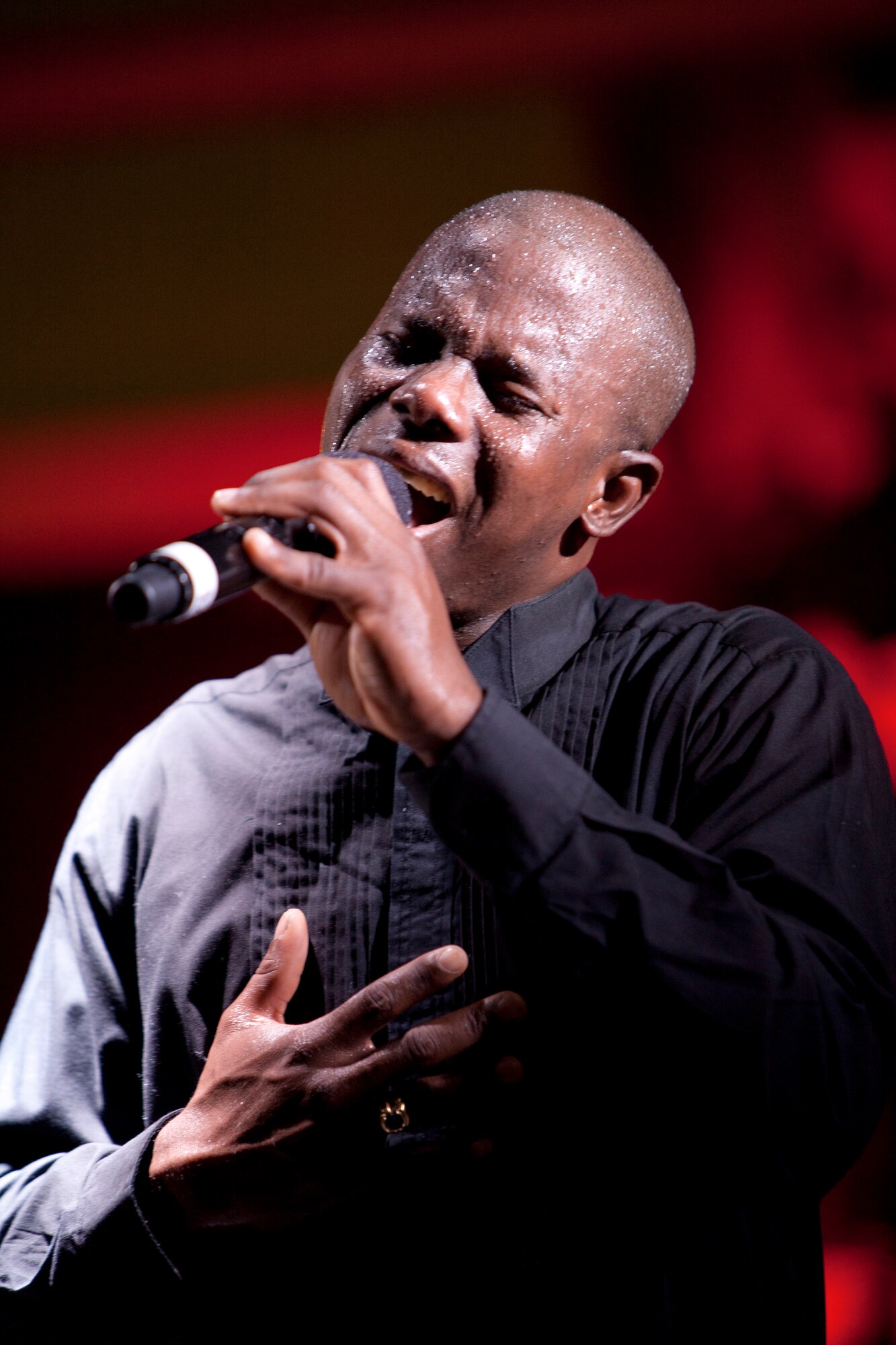 Senior Airman Hansil James sings during a Tops in Blue show July 22 at an undisclosed location in Southwest Asia. Tops In Blue is an all-active duty US Air Force special unit made up of talented amateur performers selected for their entertainment abilities.  (U.S. Air Force Photo/TSgt Sean Blumenhein)