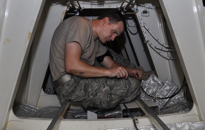 Staff Sgt. Charlie Watson works in the belly of a C-17 Globemaster III and prepares the cable that will connect to a new VHF antenna connector July 23, 2010, at Charleston Air Force Base, S.C. Sergeant Watson is a communication and navigation specialist with the 315th Aircraft Maintenance Squadron here. (U.S. Air Force photo/Staff Sgt. Shane Ellis)