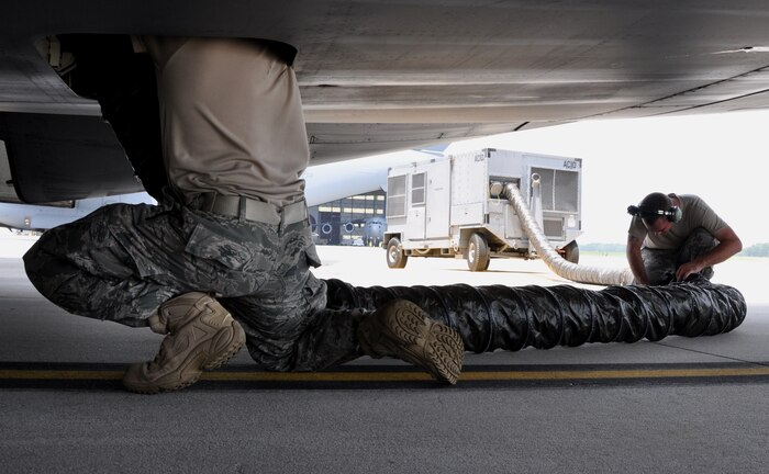 Staff Sgt. Charlie Watson and Senior Airman Jonathan Kiger work together and position the air hose of a portable air conditioning unit to supply cool air inside the belly of a C-17 Globemaster III July 23, 2010, at Charleston Air Force Base, S.C. Sergeant Watson is a communication and navigation specialist with the 315th Aircraft Maintenance Squadron here, and Senior Airman Watson is a communication and navigation specialist with the 437th Aircraft Maintenance Squadron here. (U.S. Air Force photo/Staff Sgt. Shane Ellis)