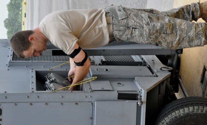 Staff Sgt. Charlie Watson prepares a portable air conditioning unit to supply cool air inside the belly of a C-17 Globemaster III July 23, 2010, at Charleston Air Force Base, S.C. Sergeant Watson is a communication and navigation specialist with the 315th Aircraft Maintenance Squadron here. (U.S. Air Force photo/Staff Sgt. Shane Ellis)
