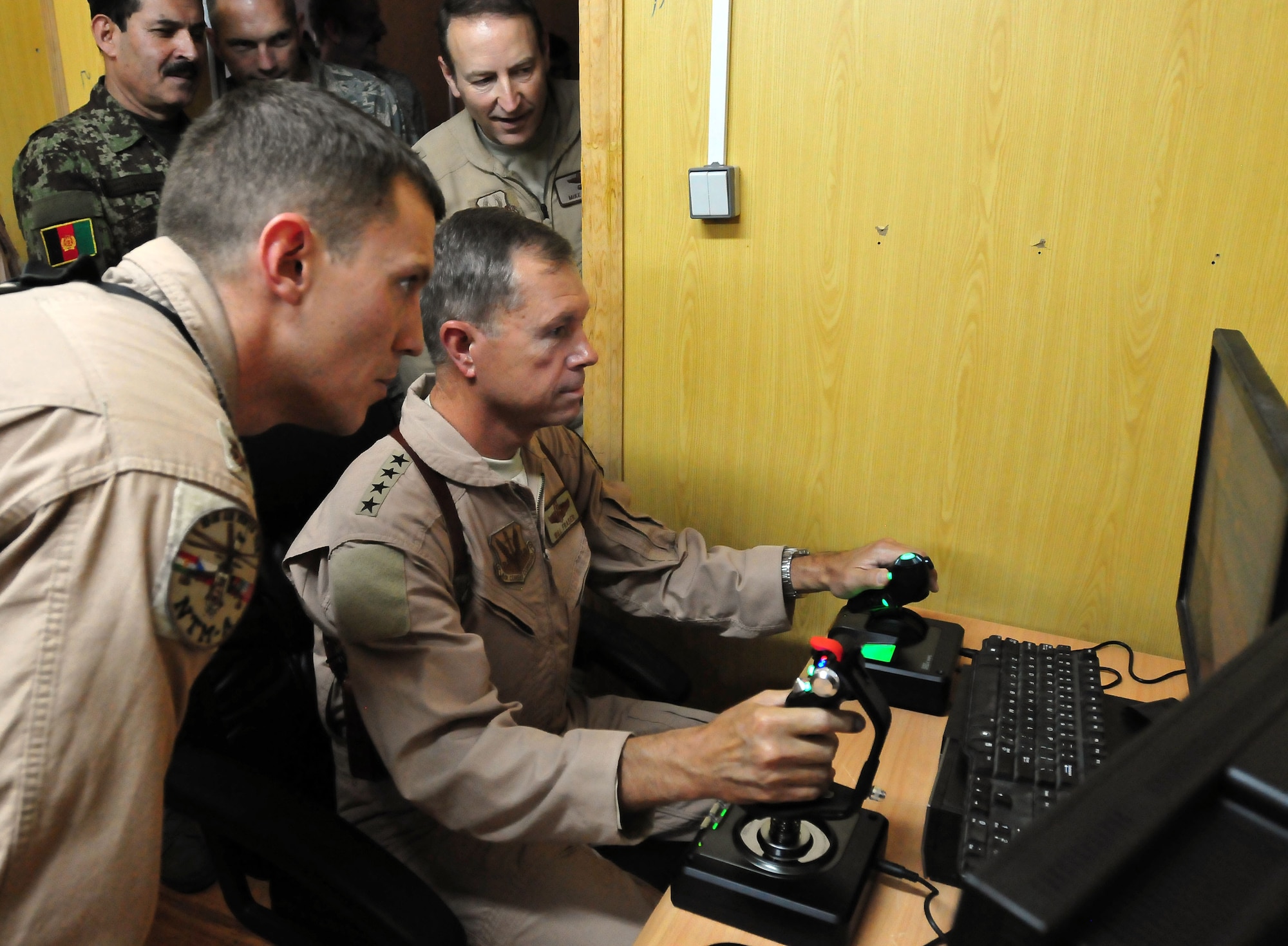 100723-N-6031Q-006 KABUL, Afghanistan - Maj. Caleb Nimmo, left, watches and provides instruction to Gen. William M. Fraser III, Commander of the Air Combat Command, as he takes his hand to the rotary wing flight simulator during his visit to the Afghan Air Force Base in Kabul on July 23, 2010. Fraser, along with Lt. Gen. Michael Hostage, U.S. Air Forces Central commander, toured the "Thunder Lab", an English immersion program for Afghan pilot candidates. The visit gave Fraser the opportunity to meet various service members working with the Combined Air Power Transition Force as well as Gen. Darwan, Commanding General of the Afghan Air Force. (US Navy photo by Mass Communication Specialist 2nd Class David Quillen/ RELEASED).