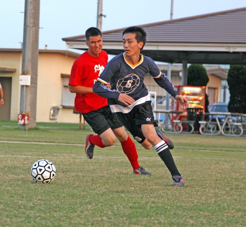 An offensive Nafi player dribbles down the field as Sean Weaver, MWSS-171 player, attempts to sneak in for the steal during an intramural soccer game at Penny Lake here July 26.