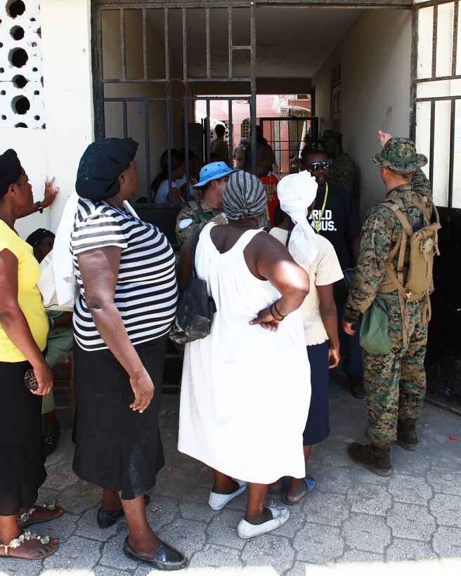 A U.S. Marine from Company A, 2nd Assault Amphibian Battalion, attached to Special-Purpose Marine Air-Ground Task Force Continuing Promise 2010, guides Haitians receiving care at a medical site in Saint-Louis du Nord, Haiti on July 26. CP10 is a collaborative effort that involves military and civilian personnel providing humanitarian assistance and disaster relief to the Caribbean, Central and South America.