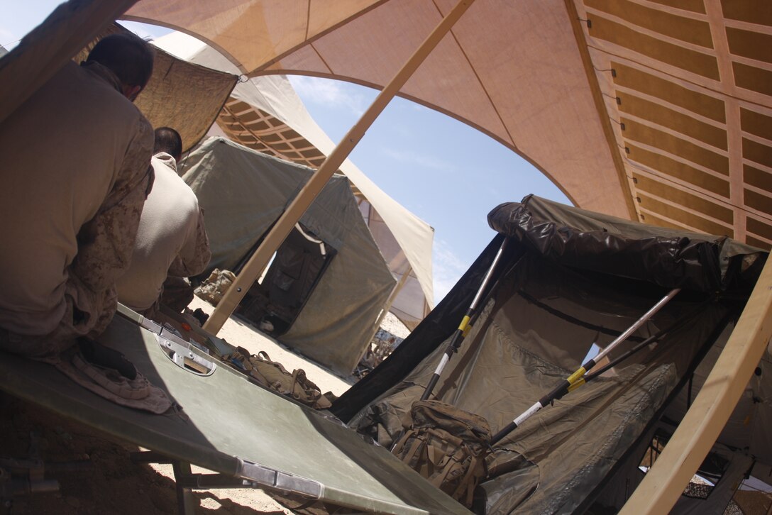MARINE CORPS AIR GROUND COMBAT CENTER TWENTYNINE PALMS, Calif. – Marines take a moment to relax and escape the brutal Mojave Desert heat under a PowerShade at Combat Center Range 220 July 26. PowerShade, is a field shelter with embedded solar panels that provide one to two kilowatts of energy to power radios, laptop computers, lighting and ventilation systems.  The Marines are with Company I, 3rd Battalion, 5th Marine Regiment, based out of Marine Corps Base Camp Pendleton, Calif.