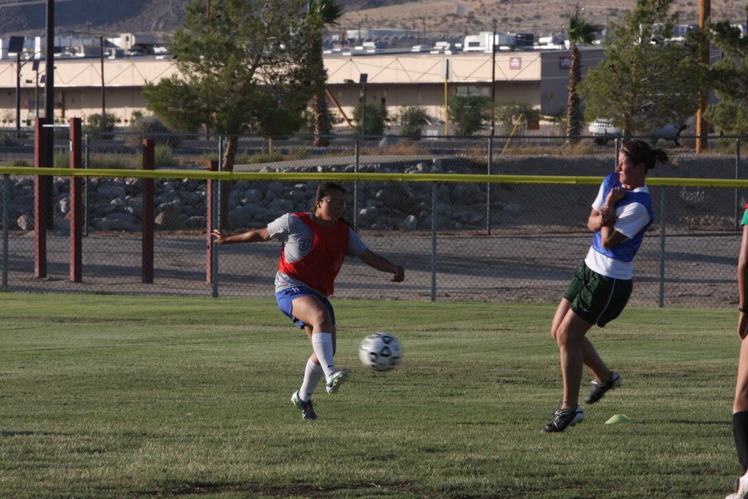 Brigitte Ng [left], a player for the women’s varsity soccer team, shoots the ball as Elissa Bohanan [right], attempts to block it during a practice July 26 at Felix Field.