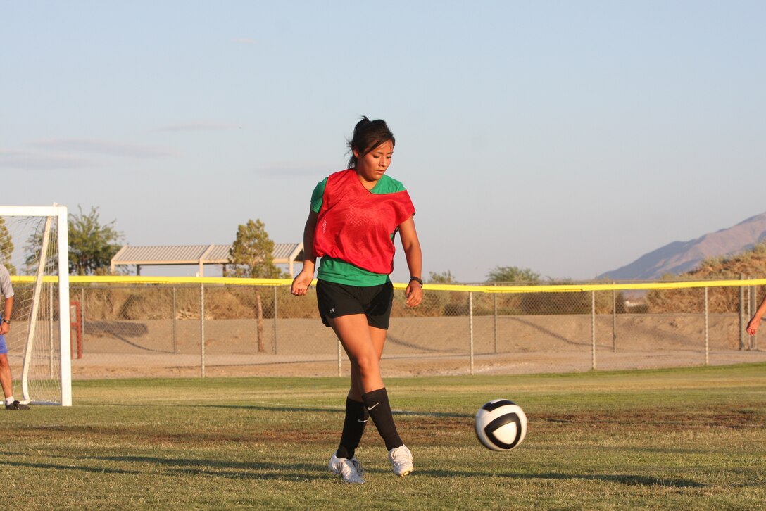 Sandy L. Santiago, a player for the women’s varsity soccer team, passes the ball to a teammate during a practice July 26 at Felix Field. For the first time in the history of the Combat Center, a women’s varsity soccer team has been formed.