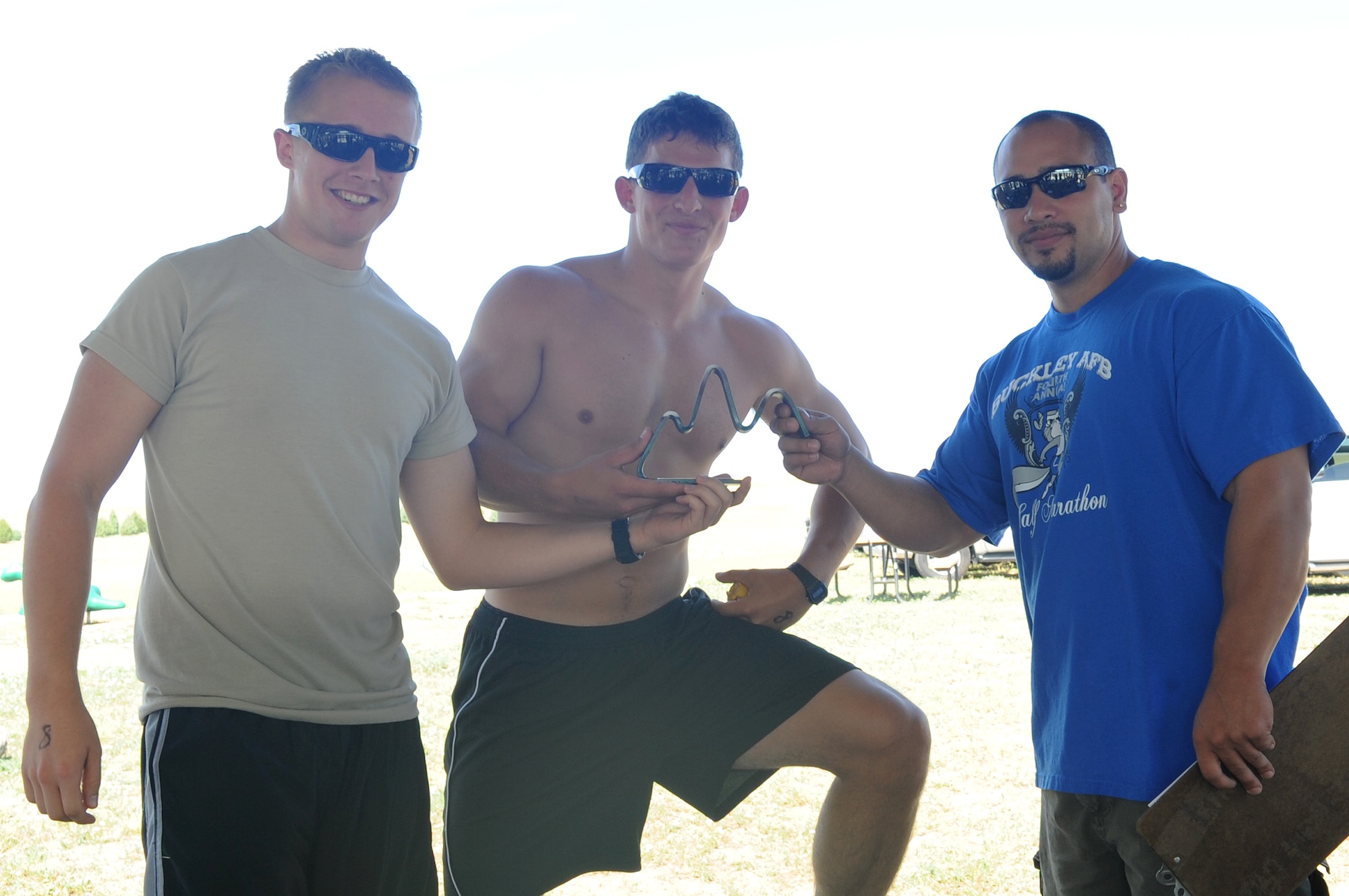BUCKLEY AIR FORCE BASE, Colo.-- Airmen Nathan Meer and Vincent Vitale, 566th Intelligence Squadron and winners of the all-male team category at the Buckley Adventureman Race July 24, receive their trophy from Bobby Padia, head of the Buckley Fitness Center. Challenges throughout the race tested the team's strength, endurance and teamwork. (U.S. Air Force Photo by Airman 1st Class Manisha Vasquez)