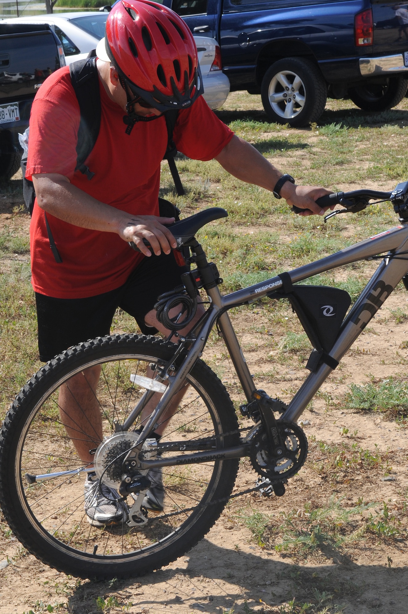 BUCKLEY AIR FORCE BASE, Colo. -- Capt. Paul Ramirez, 460th Operational Support Squadron, jumps on his bike at the Adventureman Race July 24. Each team of two shared one bike, taking turns running and biking to finish the 15-mile race. (U.S. Air Force Photo by Airman 1st Class Manisha Vasquez)