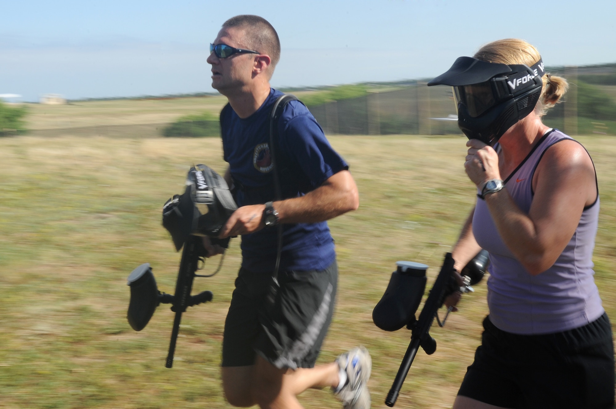 BUCKLEY AIR FORCE BASE, Colo. -- A co-ed team sprints from the paintball challege at the Adventureman Race July 24. Those teams which hit the bonus target took five minutes off their overall time. (U.S. Air Force Photo by Airman 1st Class Manisha Vasquez) 