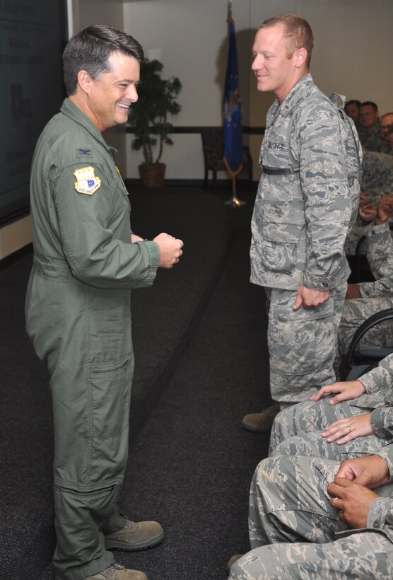 Col. Russell Fingar enjoys a moment of laughter as he prepares to coin 2nd Lt. Matthew D. Hoshor July 26, 2010, at Charleston Air Force Base, S.C. Col. Fingar is the 315th Arilift Wing vice commander, and 2nd Lt. Hoshor is an Air Force Reserve Command chaplain candidate. (U.S. Air Force photo/Staff Sgt. Shane Ellis)