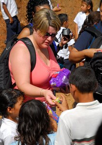EL ROBLITO, Honduras --  While the parents wait in line for food and clothes, Master Sgt. Danielle McClarin, of Joint Task Force-Bravo, hands candy to their children during the Chapel Hike here July 16. More than 50 JTF-Bravo members hiked to this remote mountain village to hand out food, clothes and other supplies to families in need. (U.S. Air Force photo/Tech. Sgt. Benjamin Rojek)