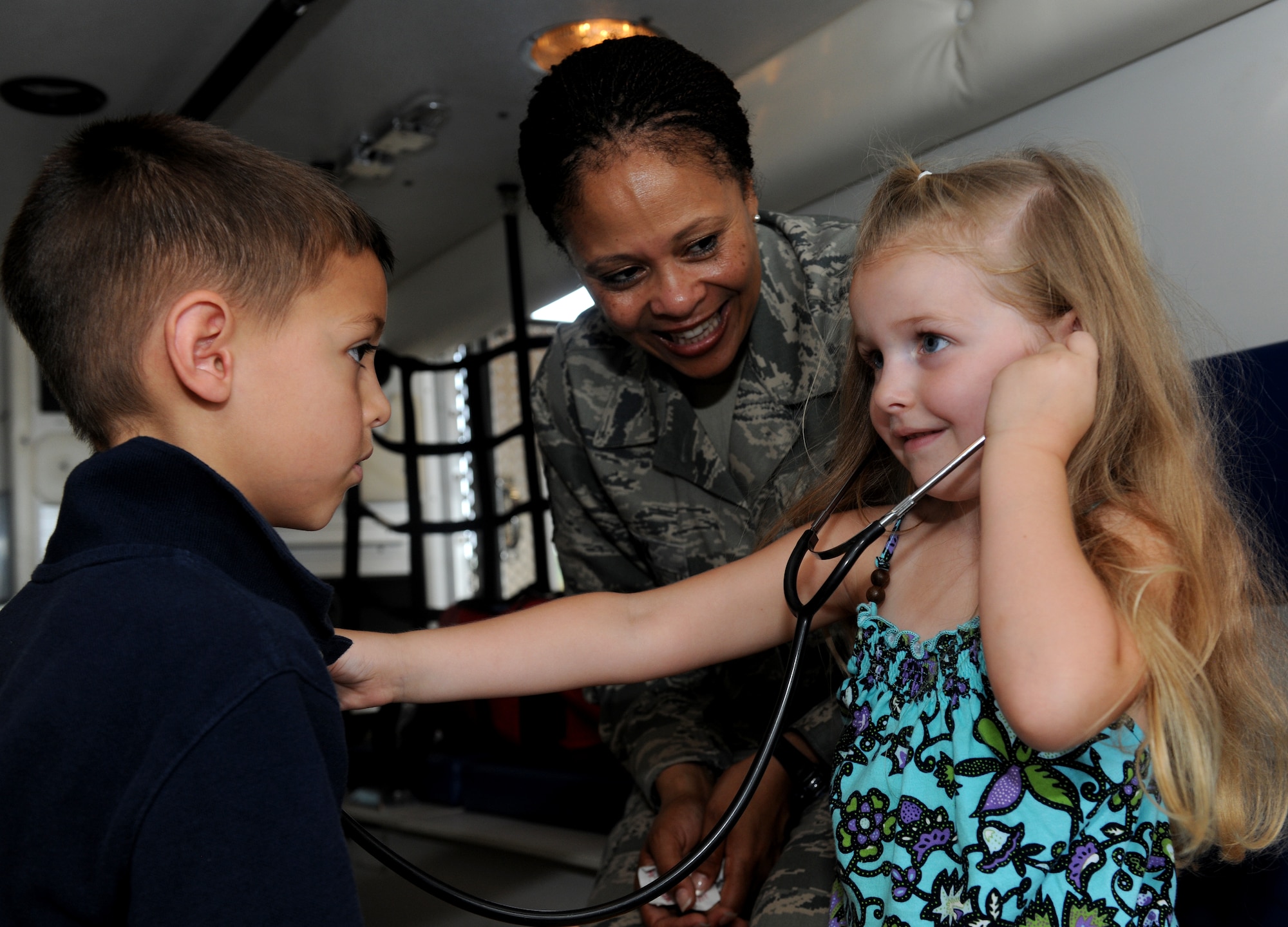MOODY AIR FORCE BASE, Ga. -- Ashlyn and Ethan, children of Staff Sgt. Paul Keller, 41st Rescue Squadron flight engineer, listen to each other’s heartbeat with a stethoscope as Master Sgt. Rachael Clark, 23rd Medical Operations Squadron superintendant, observes during Moody’s Bring Your Child to Work Day here July 23. Family members were able to interact with military members and handle equipment during their time on the base. (U.S. Air Force photo by Airman 1st Class Benjamin Wiseman/RELEASED)