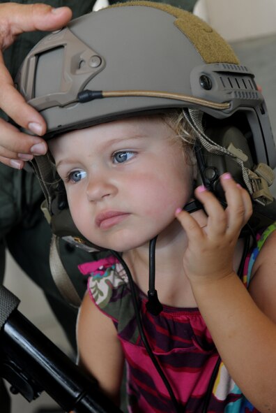 MOODY AIR FORCE BASE, Ga. -- Ellianna, daughter of Capt. Benjamin Buchta, 41st Rescue Squadron HH-60G Pave Hawk pilot, puts on a helmet during Moody’s Bring Your Child to Work Day here July 23. The helmet was part of the 38th Rescue Squadron’s pararescueman equipment on display for family members to see. (U.S. Air Force photo by Airman 1st Class Benjamin Wiseman/RELEASED)