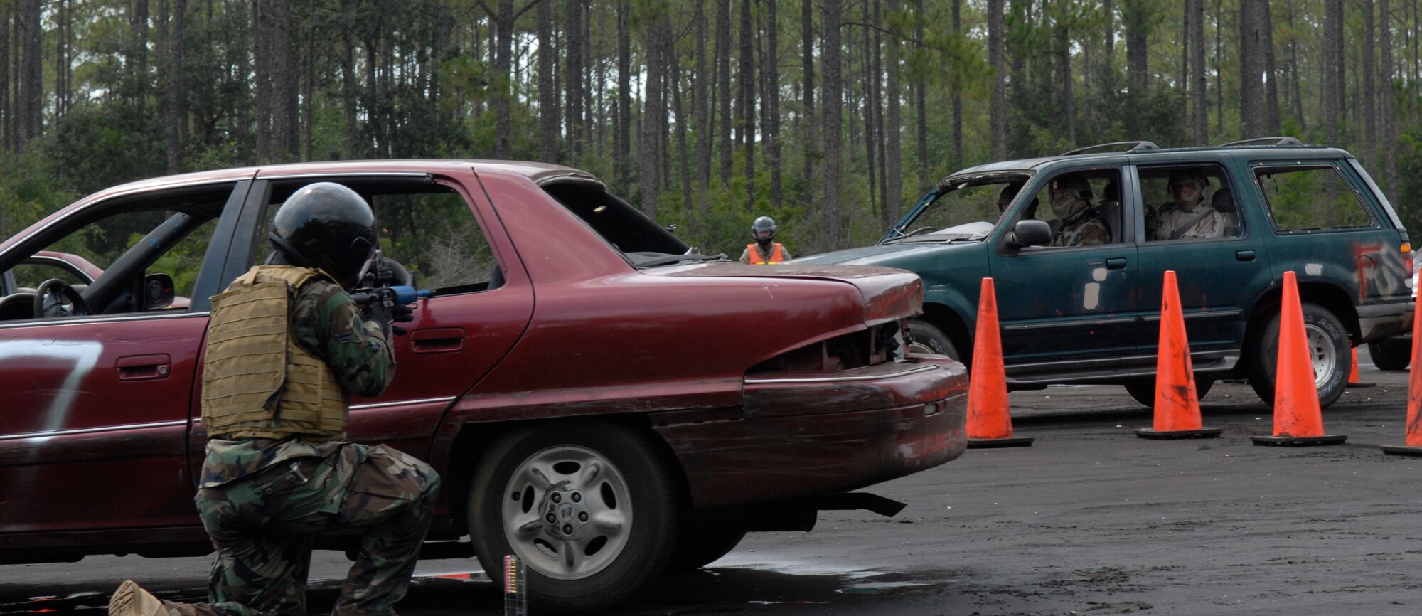 Students drive through the practice course at Eglin Range, Fla., July 23, 2010, while the shooter, played by 1st Special Operations Support Squadron Range Support flight opposition forces member, waits for the right moment to strike. In the background is another instructor, 371st Special Operations Combat Training Squadron, tasked to oversee the exercise and ensure safety measures are taken at all times. (DoD photo by U.S. Air Force Staff Sgt. Sarah Martinez)
