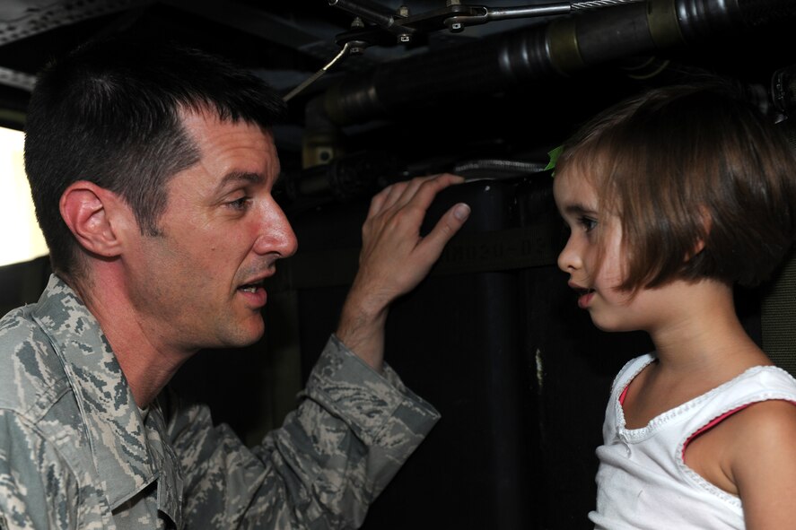 MOODY AIR FORCE BASE, Ga. -- Senior Master Sgt. Mathew Wells, 38th Rescue Squadron chief enlisted manager, speaks with his daughter Sophie inside an HH-60G Pave Hawk during Moody’s Bring Your Child to Work Day here July 23. Military members were allowed to bring their family members to the base to see Moody static displays and other equipment. (U.S. Air Force photo by Airman 1st Class Benjamin Wiseman/RELEASED)