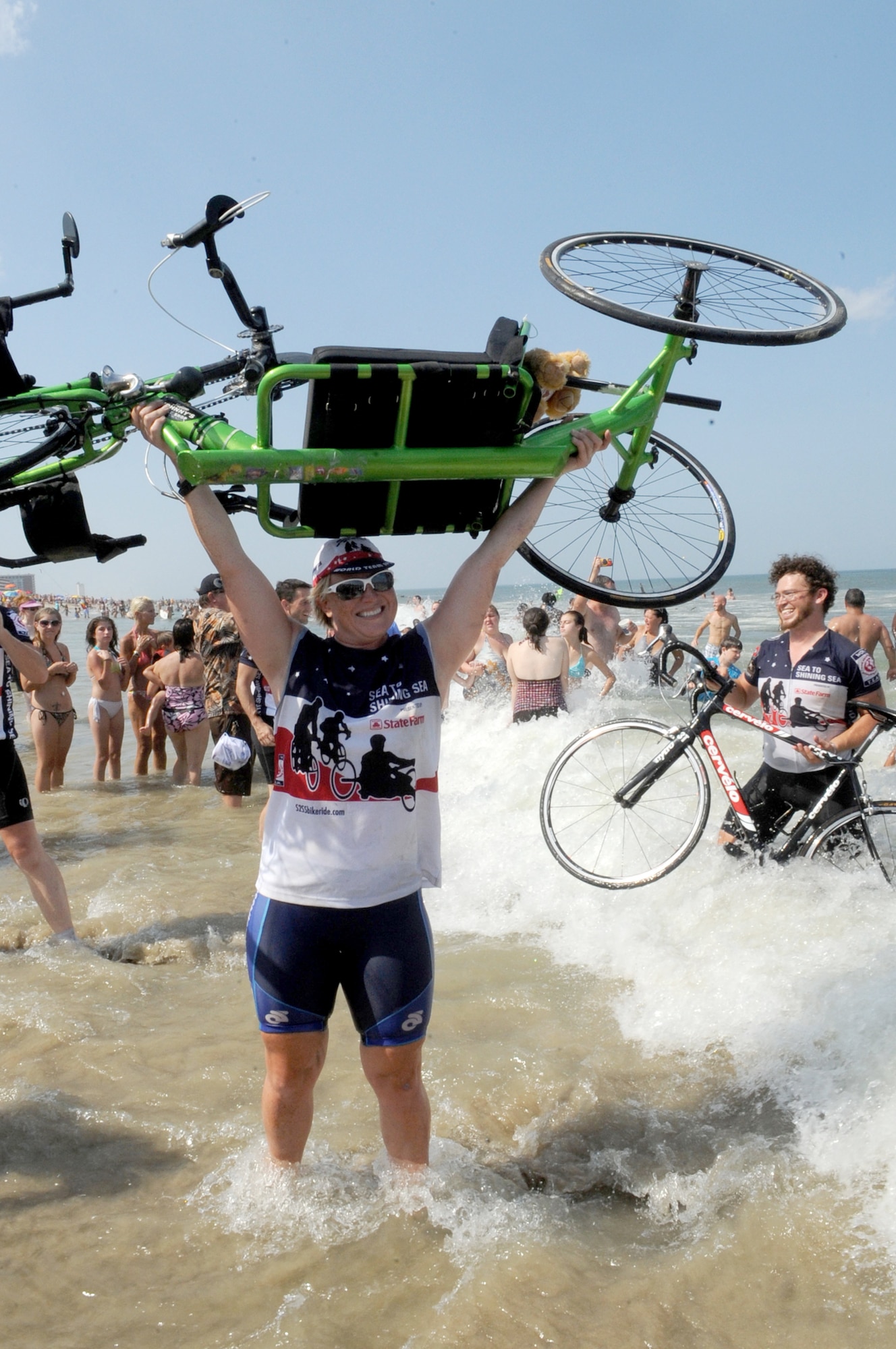 Retired Navy Petty Officer 2nd Class Nicolette Maroulis celebrates in the Atlantic Ocean during the closing ceremony of Sea to Shining Sea July 24, 2010, at Virginia Beach, Va. Sea to Shining Sea is a 4,000-mile bike ride that started at the Golden Gate Bridge in San Francisco, and ended in Virginia Beach. (U.S. Air Force photo/Staff Sgt. Christina M. Styer)