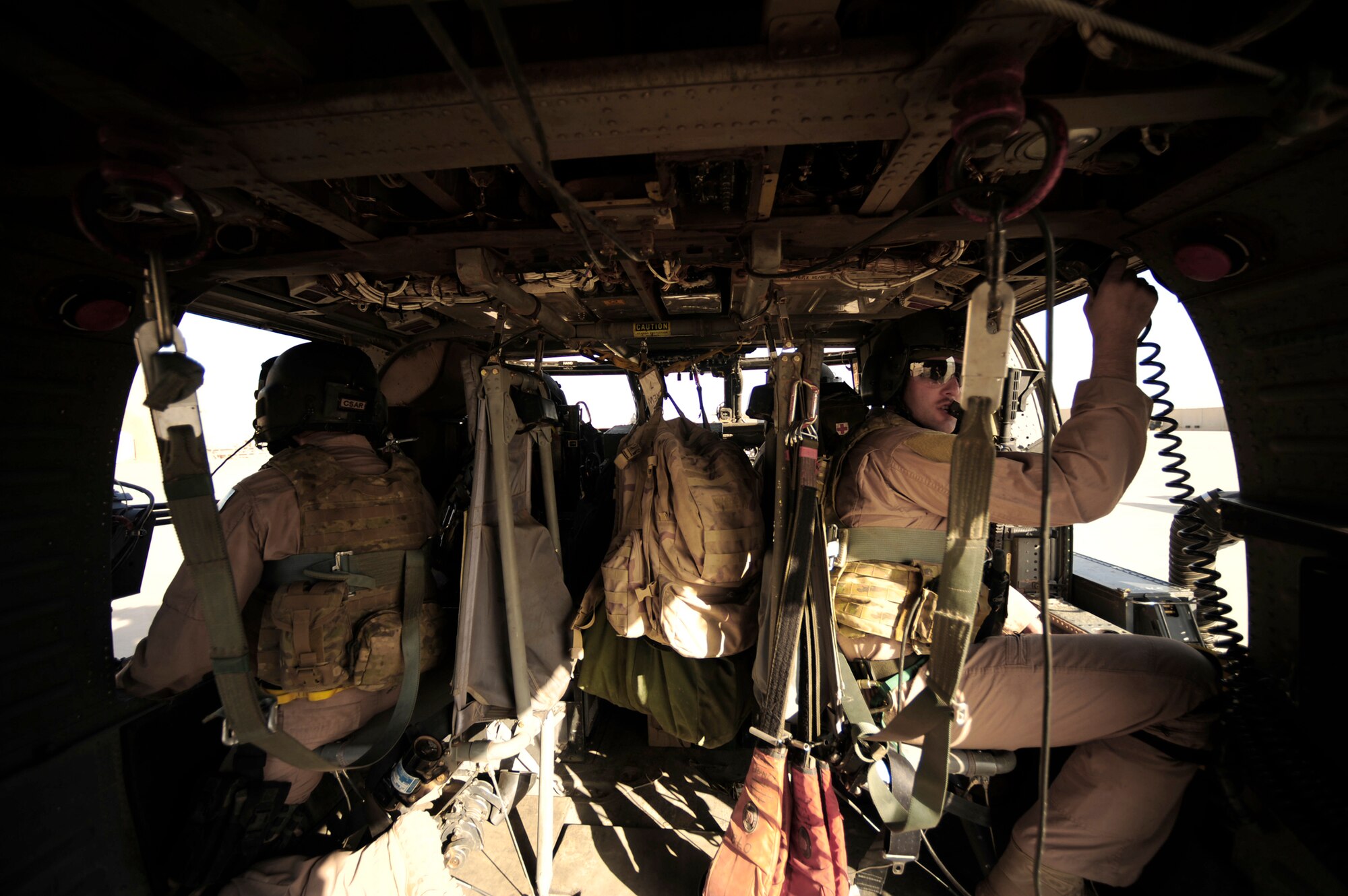Staff Sgt. Andrew Pena (left) and Staff Sgt. Aaron Walton look out their windows, scanning as aerial gunners during a mission July 12, 2010, at Joint Base Balad, Iraq.  Both sergeants are assigned to the 64th Expeditionary Rescue Squadron.  (U.S. Air Force photo/Staff Sgt. Andy M. Kin)